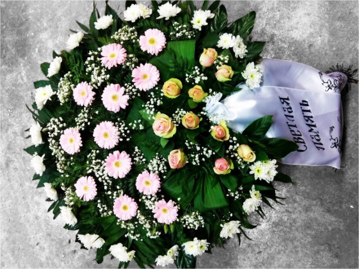 Траурный венок диаметром 90 см, выполненный из элегантных свежесрезанных цветов в нежных розовых и белых оттенках