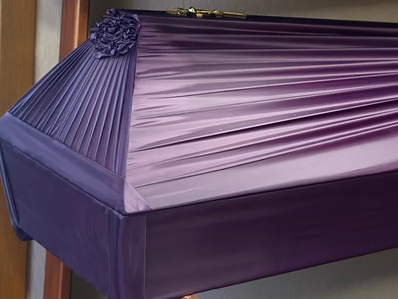 Draped wooden coffin in purple